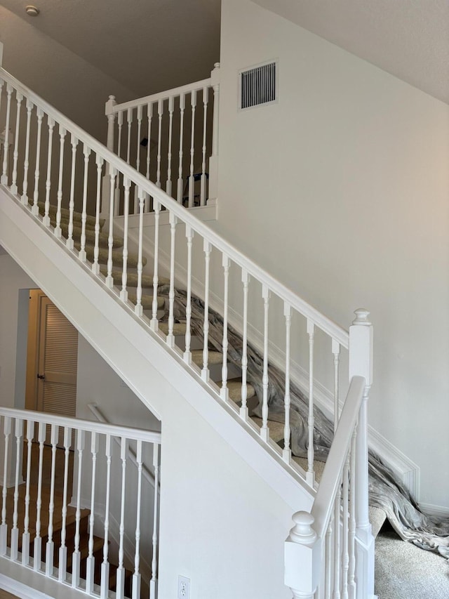 staircase featuring a high ceiling