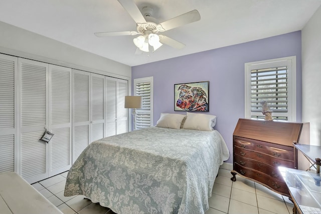 bedroom with ceiling fan, light tile patterned floors, and a closet