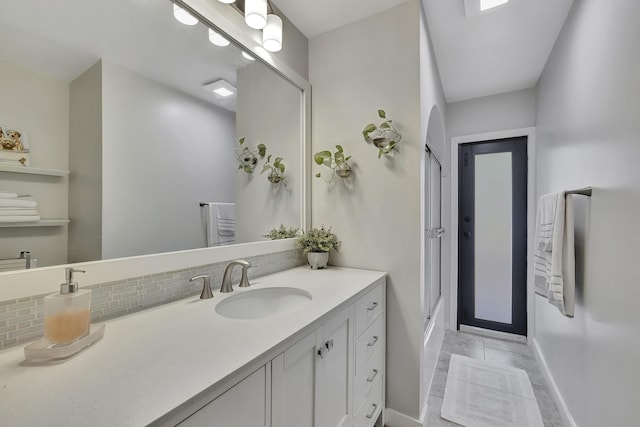 bathroom featuring tile patterned floors, vanity, walk in shower, and tasteful backsplash