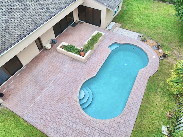 view of swimming pool with a lawn and a patio area