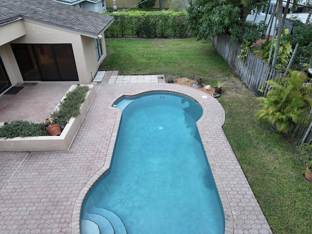 view of swimming pool featuring a patio area and a yard