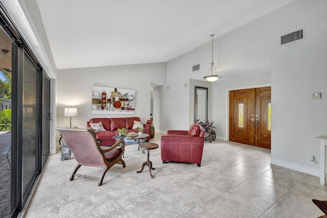 living room featuring light tile patterned floors and high vaulted ceiling