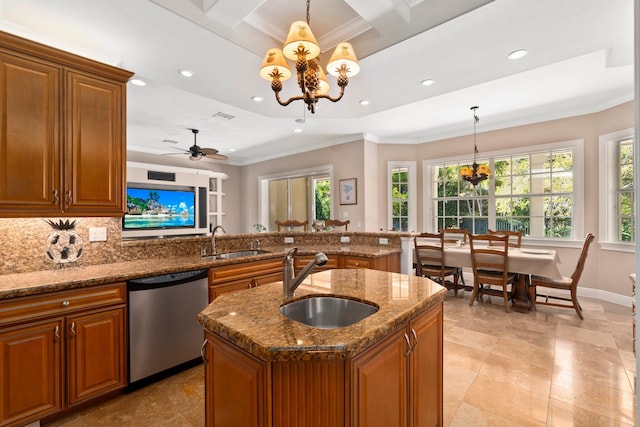 kitchen with a kitchen island with sink, sink, hanging light fixtures, stainless steel dishwasher, and ceiling fan with notable chandelier