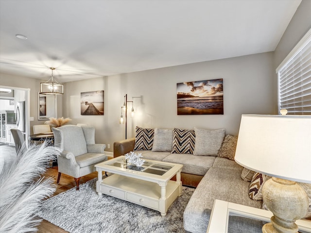 living room with hardwood / wood-style floors and a notable chandelier