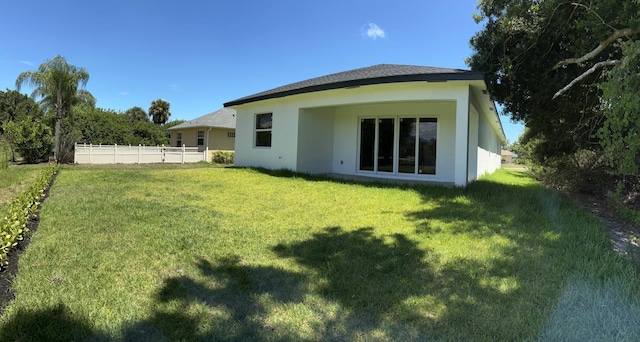 back of house with a lawn