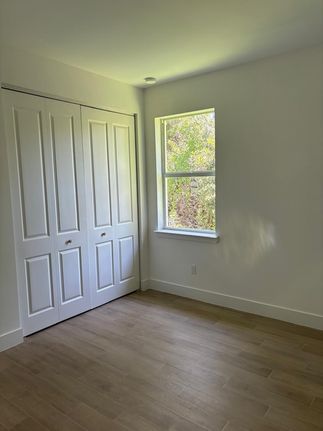 unfurnished bedroom with light hardwood / wood-style floors and a closet