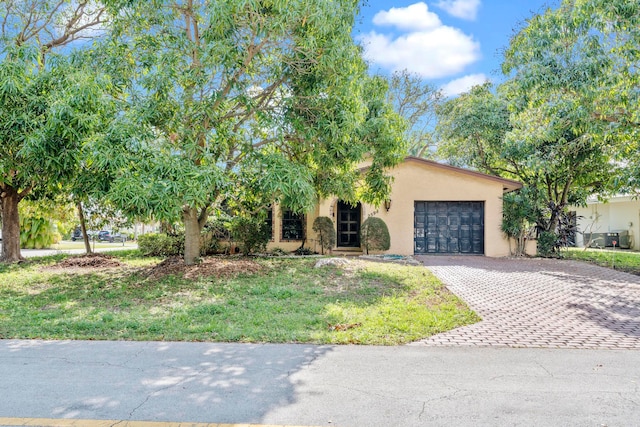 view of front of home with a front lawn and a garage