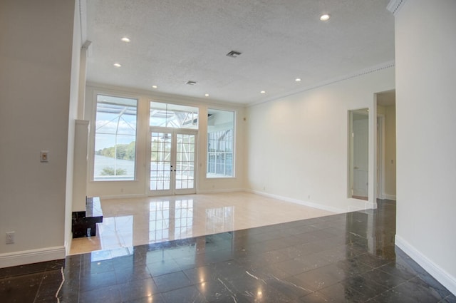 tiled spare room with a textured ceiling and french doors