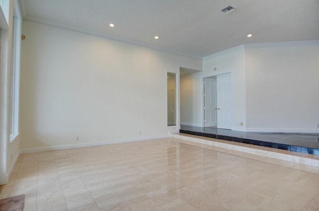 empty room with light tile floors and crown molding