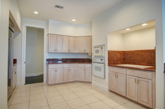 kitchen with white appliances, light brown cabinetry, and light tile flooring