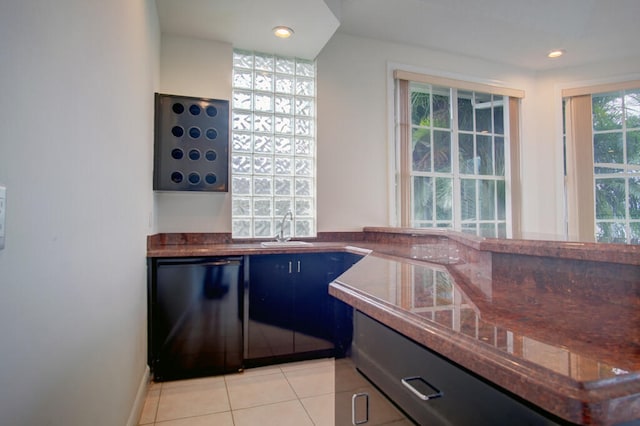 kitchen with black dishwasher, light tile floors, and sink