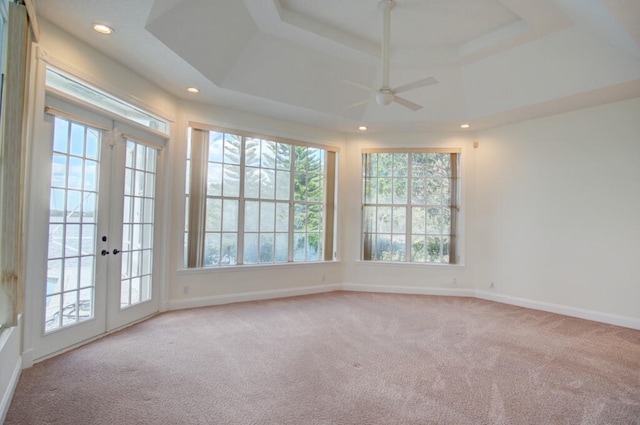 spare room featuring ceiling fan, light carpet, french doors, and a wealth of natural light