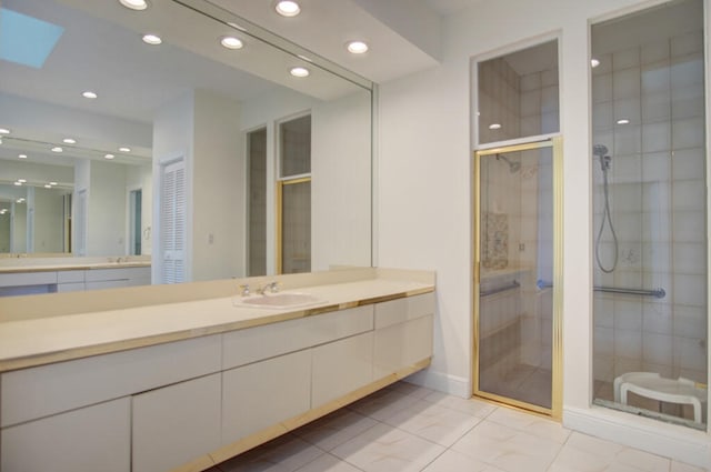 bathroom featuring a skylight, vanity, a shower with door, and tile flooring