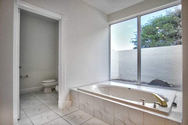 bathroom featuring tiled tub, toilet, a textured ceiling, and tile flooring