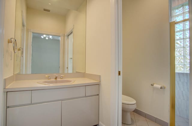 bathroom featuring toilet, tile flooring, and vanity