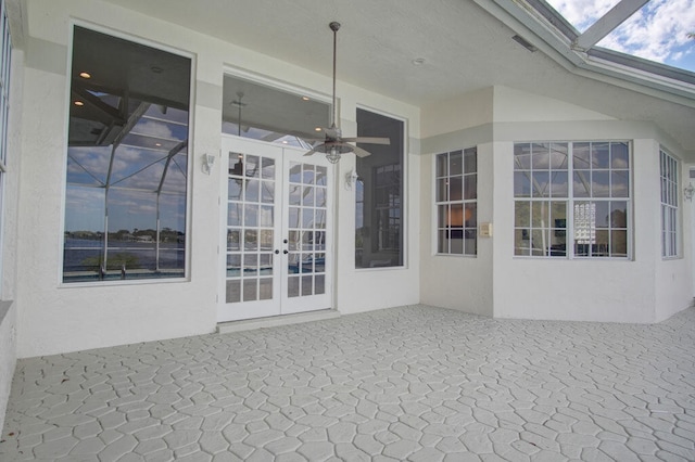 property entrance featuring french doors, ceiling fan, and a patio