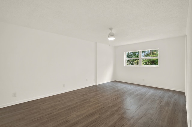 empty room with a textured ceiling and dark hardwood / wood-style floors