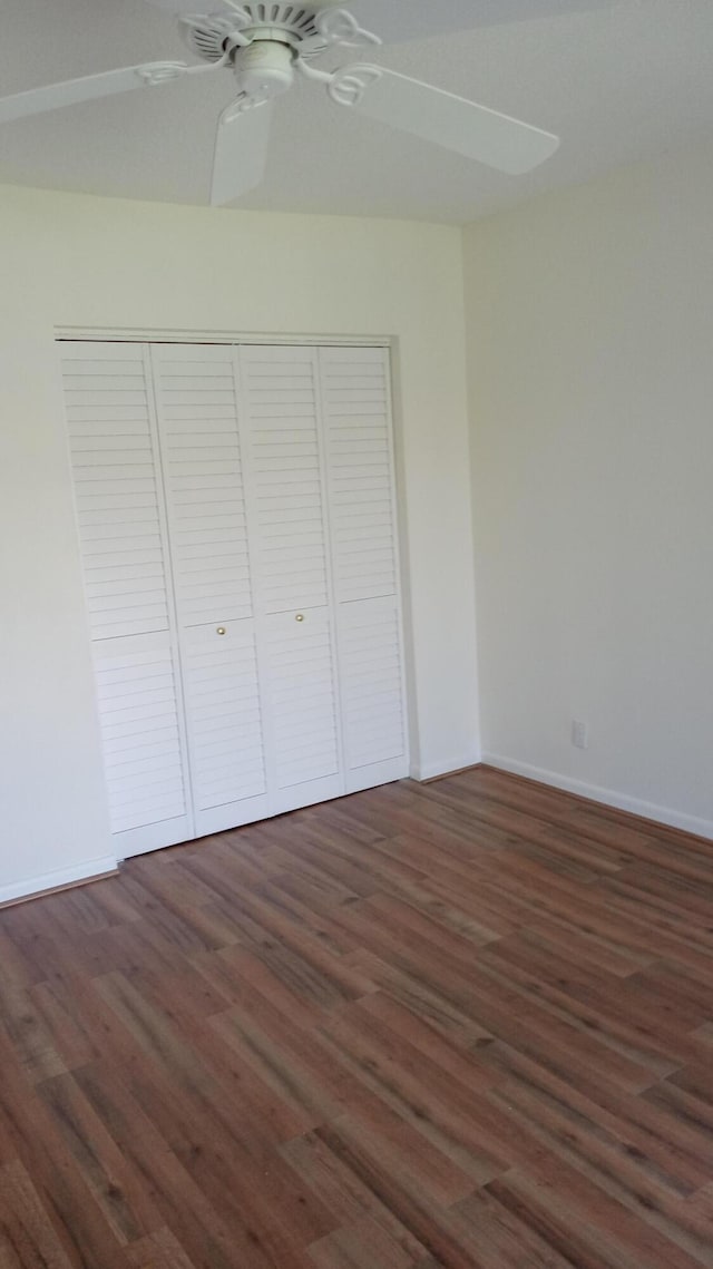 unfurnished bedroom featuring a closet, ceiling fan, and dark hardwood / wood-style flooring