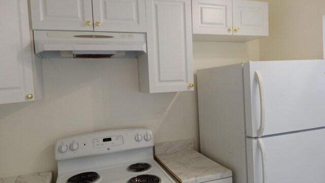 kitchen with stove, light stone countertops, white cabinetry, and white refrigerator