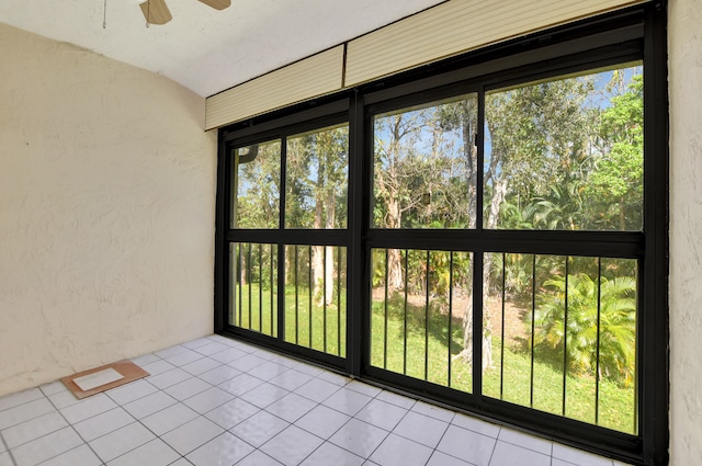 unfurnished sunroom with ceiling fan and plenty of natural light