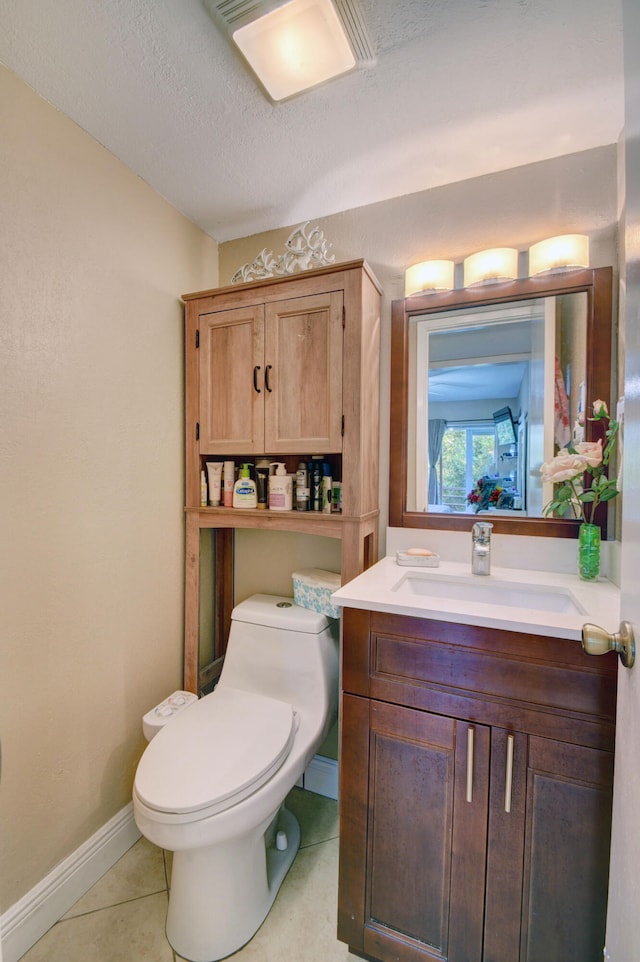 bathroom with a textured ceiling, tile patterned flooring, vanity, and toilet