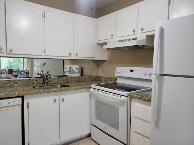 kitchen featuring white appliances, white cabinetry, dark stone countertops, and sink