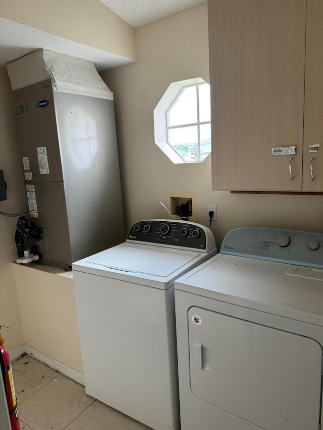 clothes washing area with washer and dryer, light tile flooring, and washer hookup