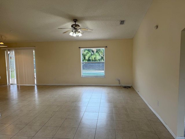 tiled empty room featuring a textured ceiling and ceiling fan