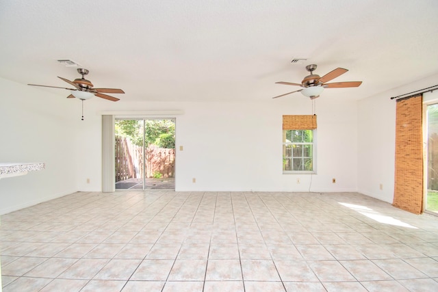 unfurnished room with light tile floors and ceiling fan