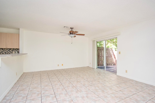 tiled spare room featuring ceiling fan