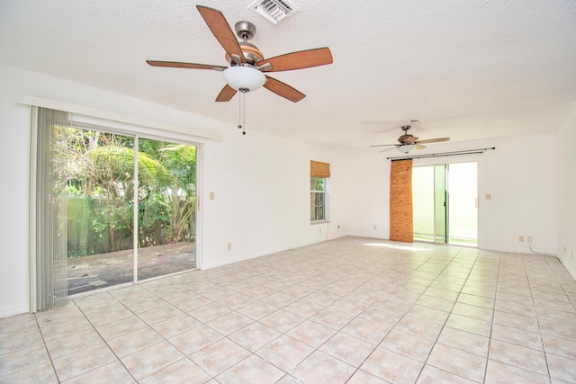 unfurnished room featuring light tile floors, plenty of natural light, and ceiling fan