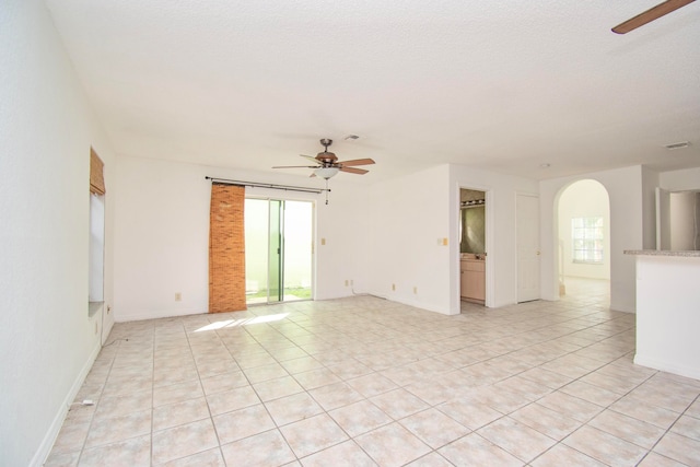 unfurnished room featuring light tile floors and ceiling fan