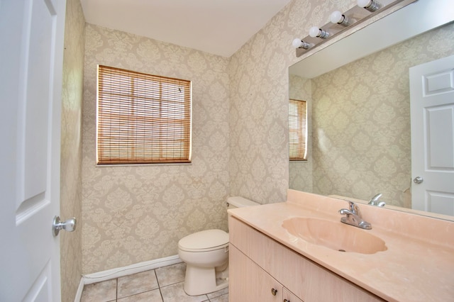 bathroom featuring toilet, large vanity, tile floors, and a healthy amount of sunlight