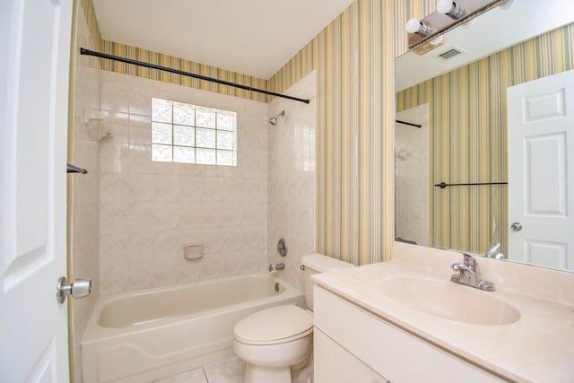 full bathroom with vanity with extensive cabinet space, toilet, tiled shower / bath, and tile flooring