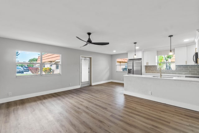 unfurnished living room with ceiling fan, dark hardwood / wood-style floors, and sink