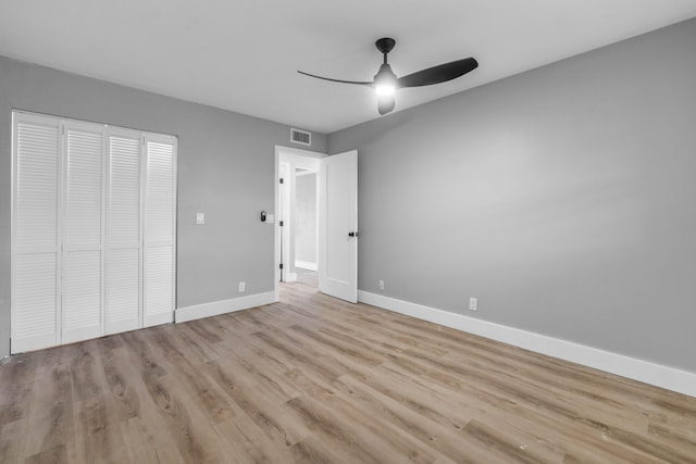 unfurnished bedroom featuring a closet, light hardwood / wood-style floors, and ceiling fan