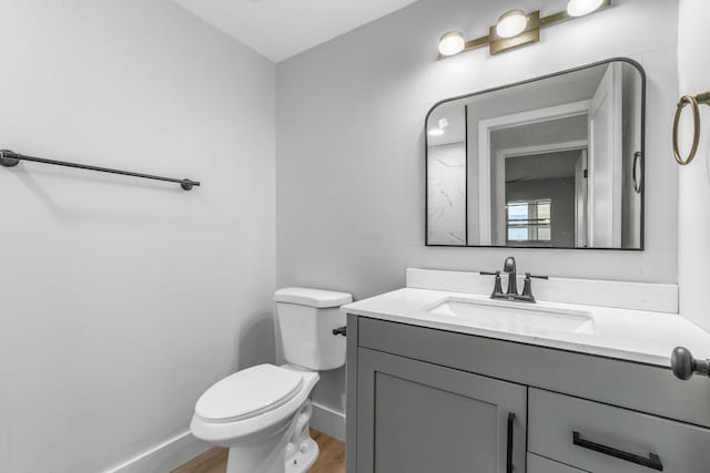 bathroom with vanity, toilet, and hardwood / wood-style flooring