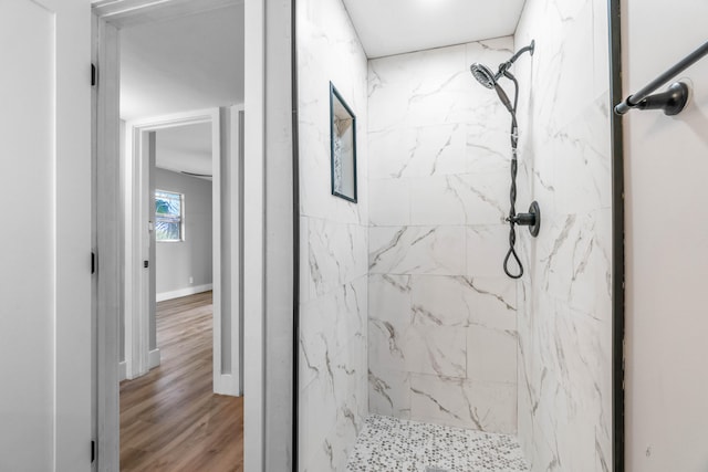 bathroom featuring a tile shower and hardwood / wood-style flooring