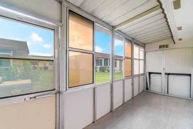 unfurnished sunroom with beamed ceiling and plenty of natural light