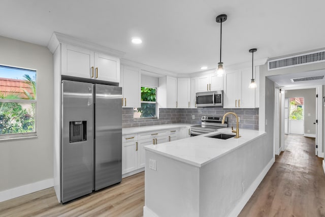 kitchen with white cabinets, light stone counters, and appliances with stainless steel finishes