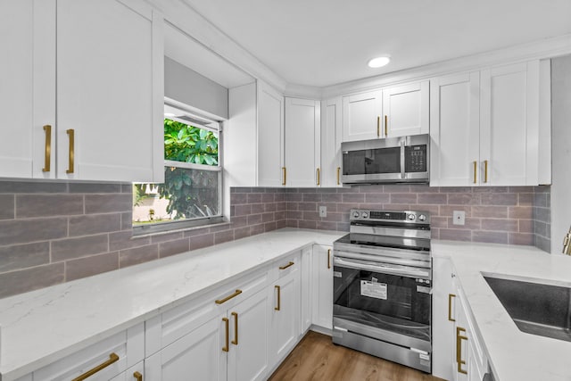 kitchen with white cabinets, stainless steel appliances, and backsplash