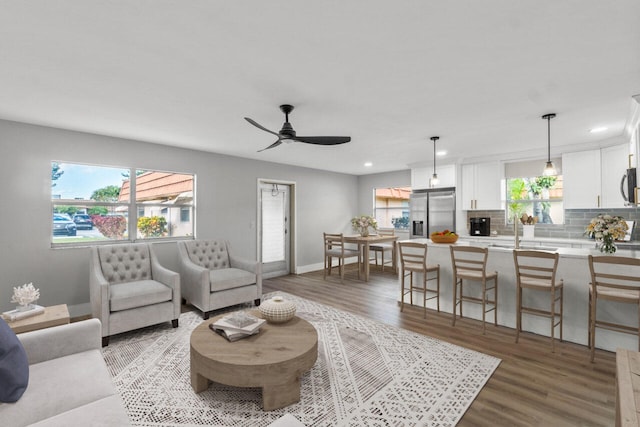 living room with light wood-type flooring and ceiling fan