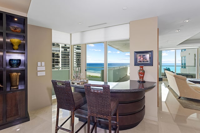 dining space featuring a water view and light tile patterned floors