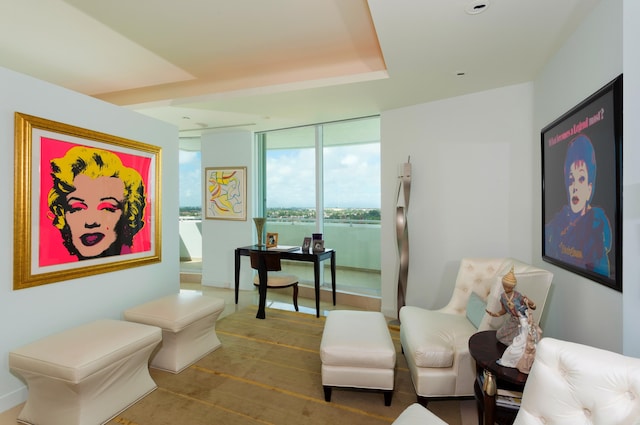 sitting room featuring a wall of windows, wood-type flooring, and a water view