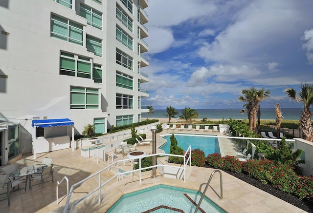 view of swimming pool with a water view and a patio area