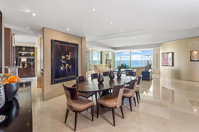 dining space with a water view and floor to ceiling windows