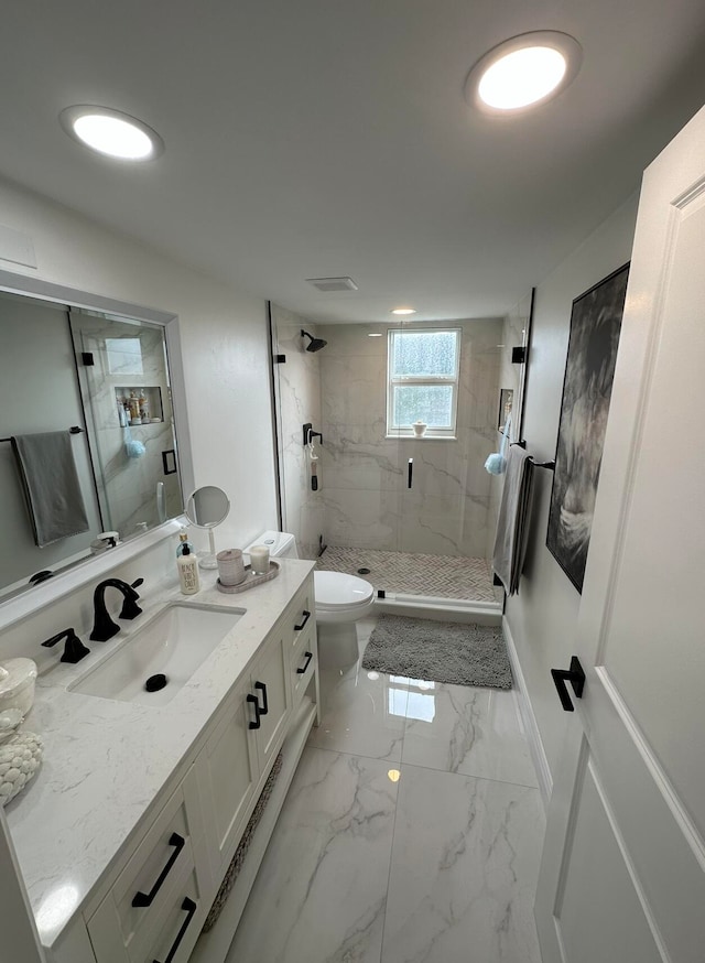 bathroom with vanity, tile floors, a tile shower, and toilet