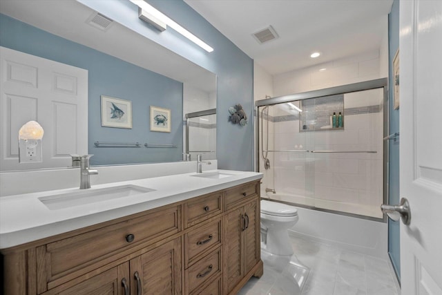 full bathroom with tile patterned floors, vanity, combined bath / shower with glass door, and toilet