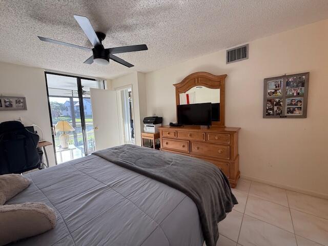 bedroom with visible vents, a ceiling fan, a textured ceiling, light tile patterned floors, and access to exterior