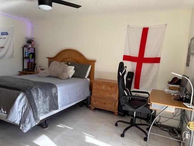 bedroom with a ceiling fan and a textured ceiling